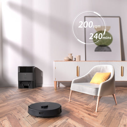 AIRROBO robot vacuum cleaner with charging station on hardwood floor next to modern gray armchair in minimalist room setting